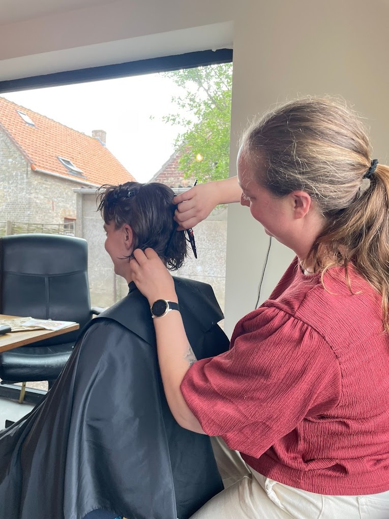 Annelies knipt halflang donker haar aan huis